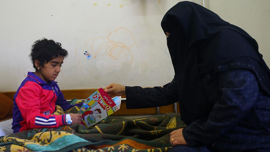 A Palestinian girl suffering from cancer sits with her mother at the al-Rantisi children's hospital in Gaza City on April 6, 2017.
The World Health Organization and others have pointed to the effect the Israeli blockade has had on medical crossings, a crucial issue for impoverished Gaza, which lacks proper medical equipment in many cases. Many patients seek treatment in Israel, and some in the occupied West Bank, the other Palestinian territory separated geographically from Gaza.
 / AFP PHOTO / MOHAMMED ABE