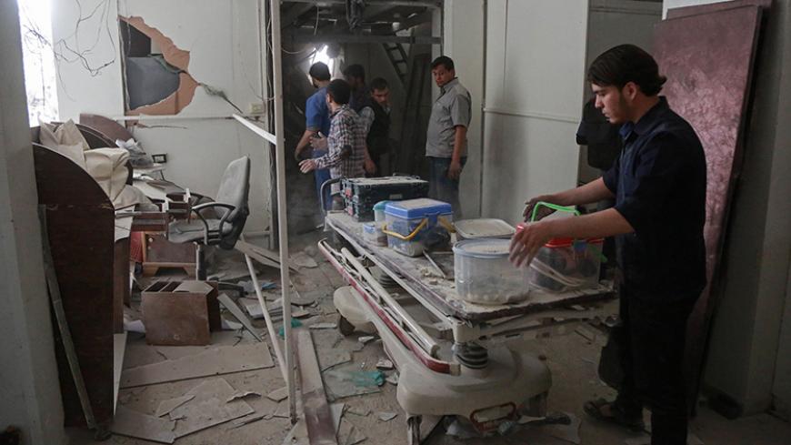 Syrians salvage medical items from a hospital following an air strike a rebel-controlled town in the eastern Ghouta region on the outskirts of the capital Damascus on May 1, 2017. 

 / AFP PHOTO / AMER ALMOHIBANY        (Photo credit should read AMER ALMOHIBANY/AFP/Getty Images)