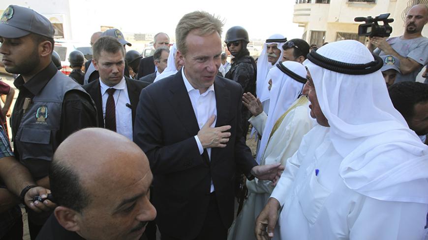 Norwegian Foreign Minister Borge Brende (C) is welcomed by Palestinians as he visits houses, which witnesses said were destroyed or damaged during the seven-week Israeli offensive, in the east of Gaza City September 8, 2014 . REUTERS/Ahmed Zakot (GAZA - Tags: POLITICS CIVIL UNREST) - RTR45D38