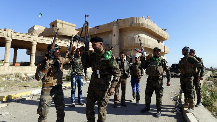 Shi'ite fighters and Sunni fighters, who have joined Shi'ite militia groups known collectively as Hashid Shaabi (Popular Mobilization), allied with Iraqi forces against the Islamic State, gesture next to former Iraqi President Saddam Hussein's palaces in the Iraqi town of Ouja, near Tikrit March 17, 2015. Iraq paused its Tikrit offensive on Monday and officials called for more air strikes against Islamic State militants, while an officer said Kurdish forces sustained two more chlorine gas attacks by insurge