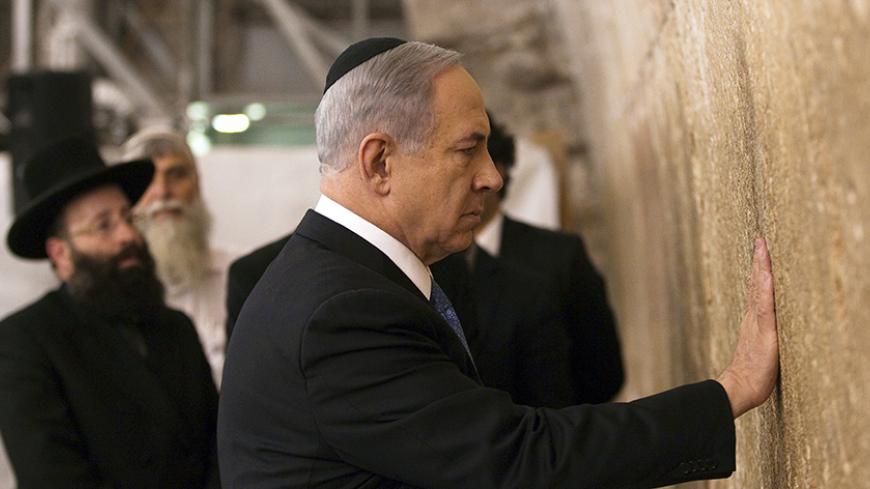 Israel's Prime Minister Benjamin Netanyahu touches the stones of the Western Wall, Judaism's holiest prayer site, in Jerusalem's Old City March 18, 2015. Netanyahu won a come-from-behind victory in Israel's election after tacking hard to the right in the final days of campaigning, including abandoning a commitment to negotiate a Palestinian state. REUTERS/Ronen Zvulun (JERUSALEM - Tags: POLITICS ELECTIONS RELIGION) - RTR4TV5K