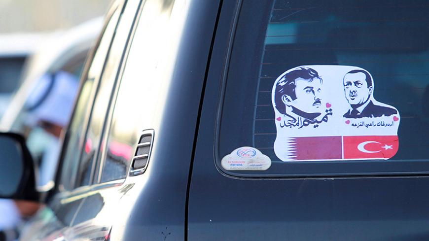 The pictures of Qatarís Emir Sheikh Tamim Bin Hamad Al-Thani (L) and Turkish President Tayyip Erdogan are seen on a car during a demonstration in support of him in Doha, Qatar June 11, 2017. REUTERS/Naseem Zeitoon - RTS16KYO