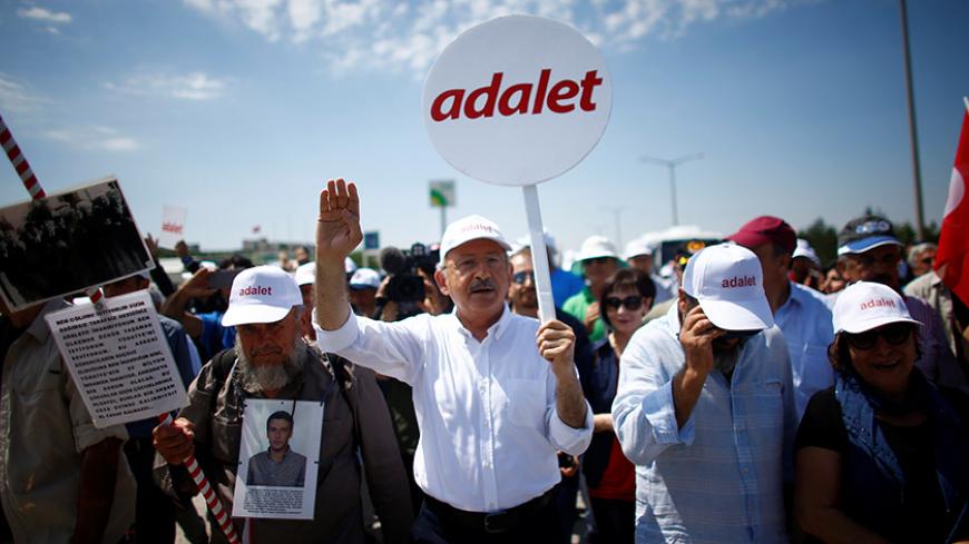 Turkey's main opposition Republican People's Party (CHP) leader Kemal Kilicdaroglu walks during the third day of a protest, dubbed "justice march", against the detention of his party's lawmaker Enis Berberoglu, on the outskirts of Ankara, Turkey June 17, 2017. Placard reads, "Justice". REUTERS/Osman Orsal - RTS17GE4