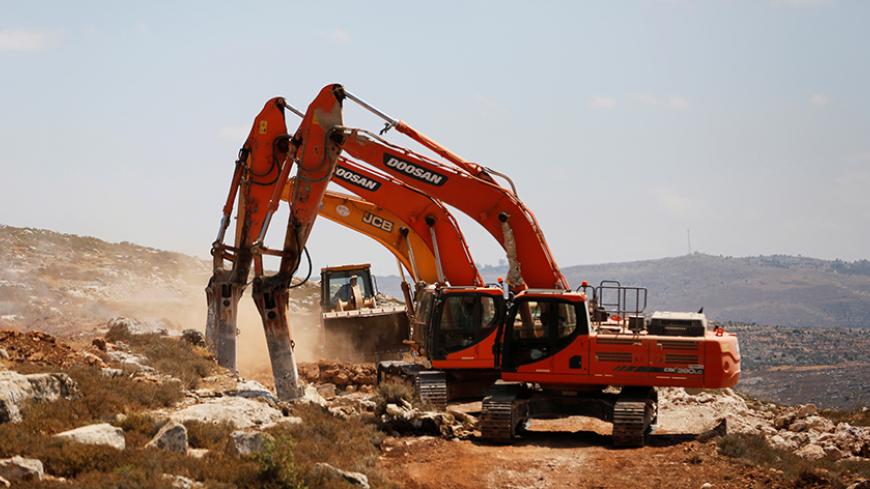 Heavy machinery work on a field as they begin construction work of Amichai, a new settlement which will house some 300 Jewish settlers evicted in February from the illegal West Bank settlement of Amona, in the West Bank June 20, 2017. REUTERS/Ronen Zvulun - RTS17UHK
