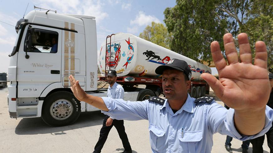 Palestinian policemen loyal to Hamas stand guard as fuel tankers enter Gaza through the Rafah border between Egypt and southern Gaza Strip June 21, 2017. REUTERS/Ibraheem Abu Mustafa - RTS180DS
