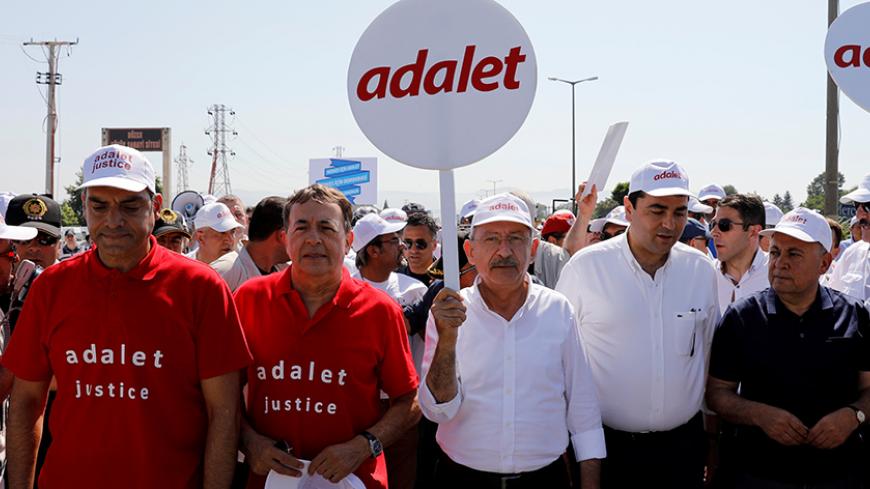 Turkey's main opposition Republican People's Party (CHP) leader Kemal Kilicdaroglu (C) and Secretay General of the Socialist International Luis Ayala (2nd L) walk flanked by supporters during the 14th day of a protest dubbed "justice march" against the detention of CHP's lawmaker Enis Berberoglu, in Duzce, Turkey June 28, 2017. The placard reads "Justice". REUTERS/Umit Bektas - RTS18YW1