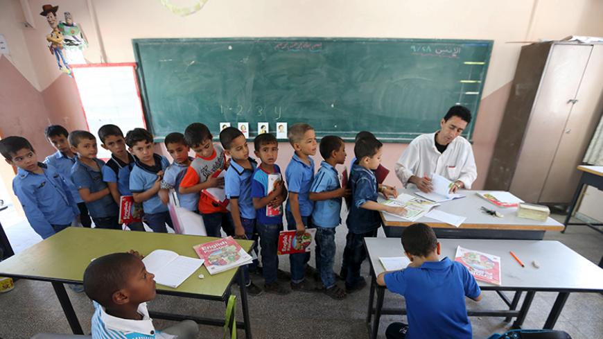 Mohammed Zurob marks an exercise for his first grade students during an English lesson inside a classroom at Taha Huseen elementary school in Rafah in the southern Gaza Strip September 28, 2015. Nearly three years after Taliban gunmen shot Pakistani schoolgirl Malala Yousafzai, the teenage activist last week urged world leaders gathered in New York to help millions more children go to school. World Teachers' Day falls on 5 October, a Unesco initiative highlighting the work of educators struggling to teach c