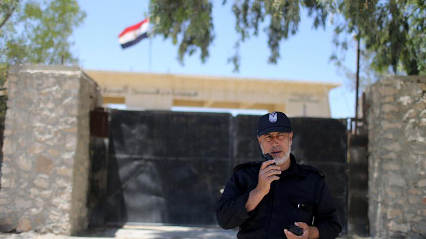 A member of the Palestinian security forces loyal to Hamas speaks on a walkie-talkie at Rafah border crossing between Egypt and southern Gaza Strip May 19, 2016. REUTERS/Ibraheem Abu Mustafa   - RTSEZZG