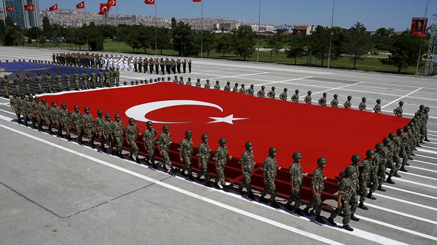 Turkish soldiers carry a huge national flag and a portrait of Mustafa Kemal Ataturk, founder of modern Turkey, during a military parade marking the 93rd anniversary of Victory Day in Ankara, Turkey, August 30, 2015. REUTERS/Umit Bektas - RTX1Q9O8
