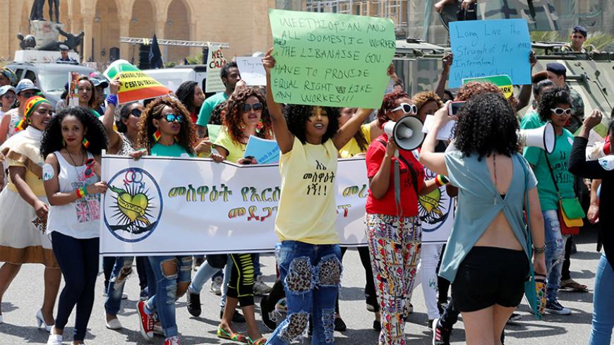 Migrant domestic workers hold placards and chant slogans during a parade to support the rights of migrant domestic workers, on May Day in downtown Beirut, Lebanon May 1, 2016. REUTERS/Mohamed Azakir - RTX2CB24