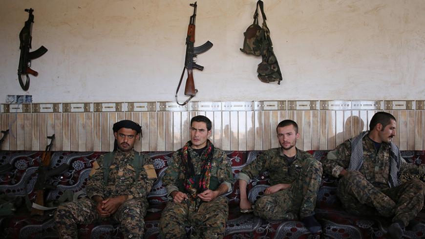 Members of the Sinjar Resistance Units (YBS), a militia affiliated with the Kurdistan Workers' Party (PKK), sit with an Arab tribal fighter (L) in a house in the village of Umm al-Dhiban, northern Iraq, April 30, 2016. They share little more than an enemy and struggle to communicate on the battlefield, but together two relatively obscure groups have opened up a new front against Islamic State militants in a remote corner of Iraq. The unlikely alliance between the Sinjar Resistance Units, an offshoot of a le