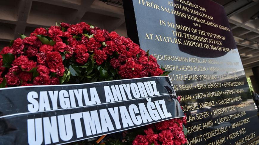TOPSHOT - A wreath reading "We will not forget" and a commemorative plaque are pictured during a memorial ceremony on June 28, 2017 at Ataturk International airport in Istanbul, one year since the triple suicide bombing and gun attack by Islamic State (IS) jihadists. 
Turkey on June 28 marked one year since the triple suicide bombing and gun attack on its main international airport in Istanbul that left dozens dead and was blamed on Islamic State (IS) jihadists.  / AFP PHOTO / OZAN KOSE        (Photo credit