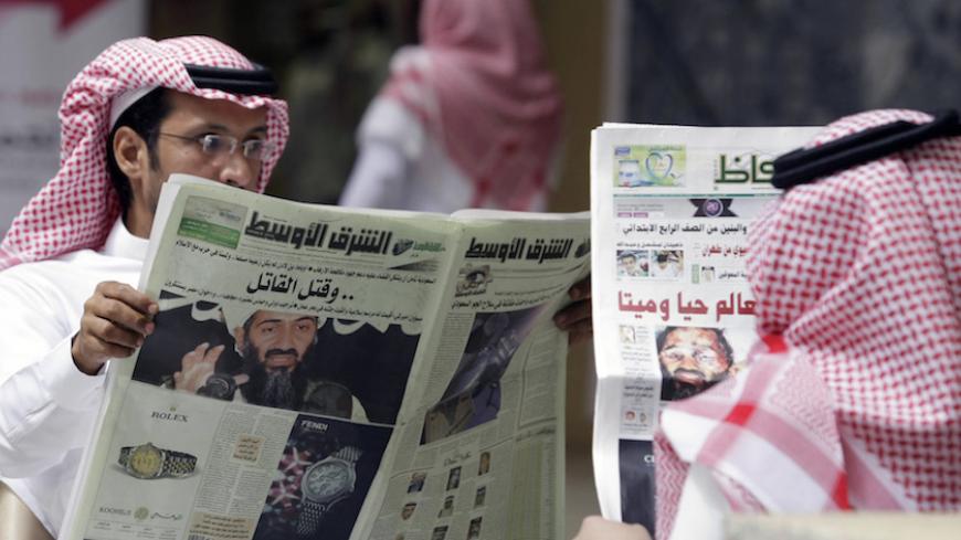 People read the newspapers with cover stories of Osama bin Laden, in Riyadh, May 3, 2011. Bin Laden was killed in a U.S. special forces assault on a Pakistani compound, then quickly buried at sea, in a dramatic end to the long manhunt for the al Qaeda leader who had been the guiding star of global terrorism. REUTERS/Mohammed Mashhor    (SAUDI ARABIA - Tags: SOCIETY MEDIA) - RTR2LXUQ