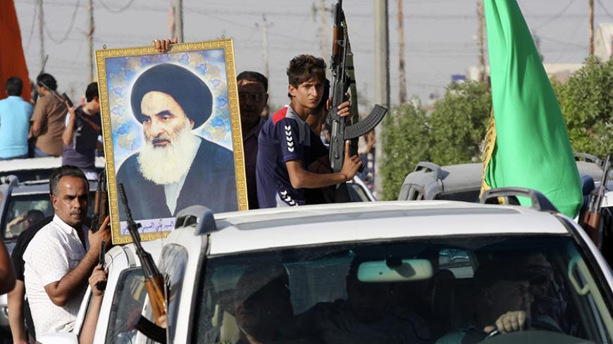 Volunteers, who have joined the Iraqi Army to fight against predominantly Sunni militants, carry weapons and a portrait of Grand Ayatollah Ali al-Sistani during a parade in the streets in Baghdad's Sadr city June 14, 2014. An offensive by insurgents that threatens to dismember Iraq seemed to slow on Saturday after days of lightning advances as government forces regained some territory in counter-attacks, easing pressure on the Shi'ite-led government in Baghdad.  REUTERS/Wissm al-Okili   (IRAQ - Tags: CIVIL 