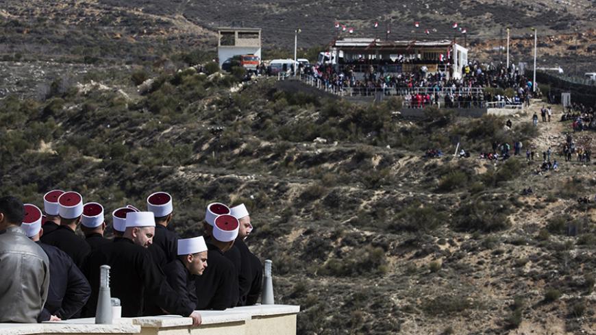 Members of the Druze community look at their friends and relatives (R) on the Syrian side of the border, during a rally in the Druze village of Majdal Shams on the Golan Heights, which stands at the heart of a long-standing conflict between Israel and Syria, February 14, 2014. Hundreds of members of the Druze community took part in the rally on Friday, marking the 33rd anniversary of Israel's annexation of the strategic plateau which it captured in the 1967 Middle East War. REUTERS/Baz Ratner (POLITICS ANNI