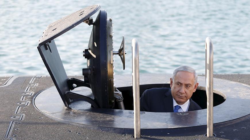 Israeli Prime Minister Benjamin Netanyahu climbs out after a visit inside the Rahav, the fifth submarine in the fleet, after it arrived in Haifa port January 12, 2016. The Dolphin-class submarines, widely believed to be capable of firing nuclear missiles, were manufactured in Germany and sold to Israel at deep discounts as part of Berlin's commitment to shoring up the security of the country set in part as a haven for Jews who survived the Holocaust.REUTERS/Baz Ratner - RTX221FU