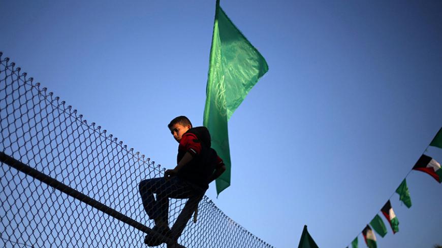 A Palestinian boy climbs over a fence during a rally marking the 29th anniversary of the founding of the Hamas movement, in Khan Younis in the southern Gaza Strip December 11, 2016. REUTERS/Ibraheem Abu Mustafa - RTX2UIXX