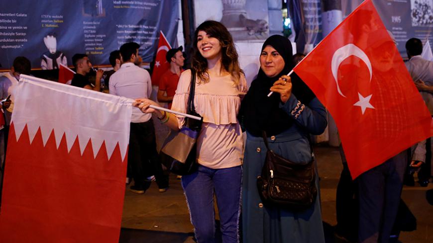 Women pose with Turkish and Qatari flags during a demonstration in favour of Qatar in central Istanbul, Turkey, late June 7, 2017. REUTERS/Murad Sezer - RTX39JA3