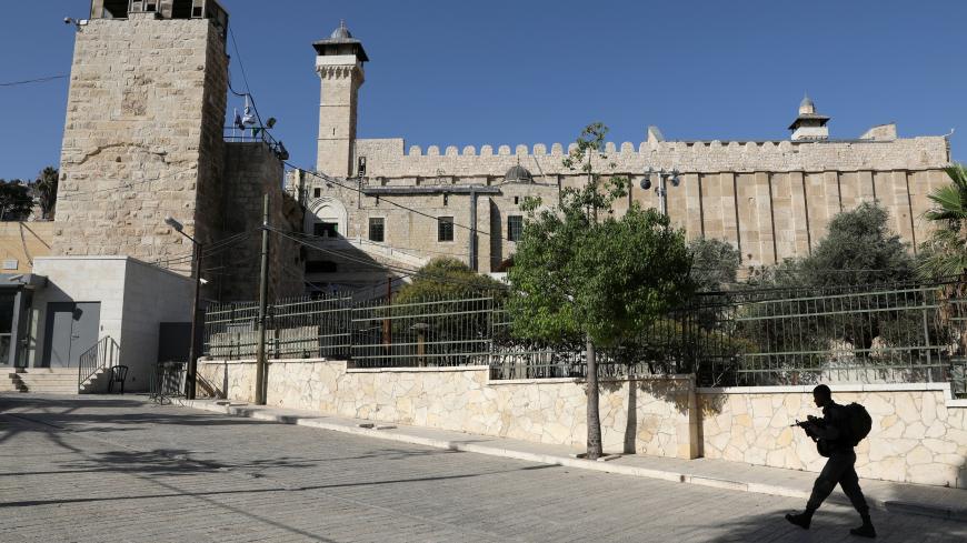 An Israeli soldier walks past Ibrahimi Mosque, which Jews call the Jewish Tomb of the Patriarchs, in the West Bank city of Hebron July 7, 2017. REUTERS/Ammar Awad - RTX3AJ9Z