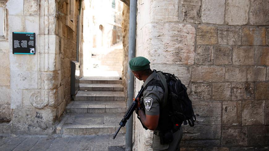 An Israeli border police officer guards next to an entrance leading to the compound known to Muslims as Noble Sanctuary and to Jews as Temple Mount, in Jerusalem's Old City July 16, 2017. REUTERS/Ronen Zvulun - RTX3BMMA