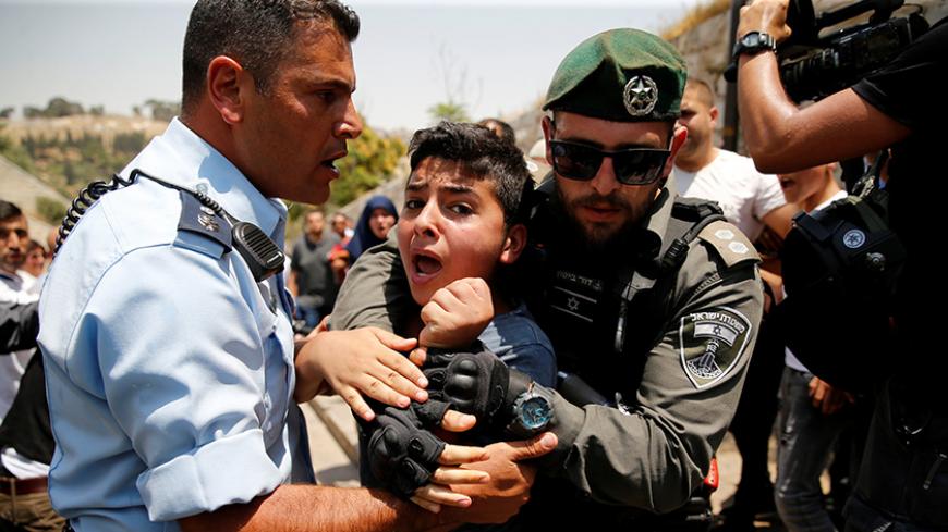 A Palestinian youth is detained by an Israeli border police officer during scuffles that erupted after Palestinians held prayers just outside Jerusalem's Old City in protest over the installation of metal detectors placed at an entrance to the Old City's compound known to Muslims as Noble Sanctuary and to Jews as Temple Mount July 17, 2017. REUTERS/Ammar Awad - RTX3BRG6