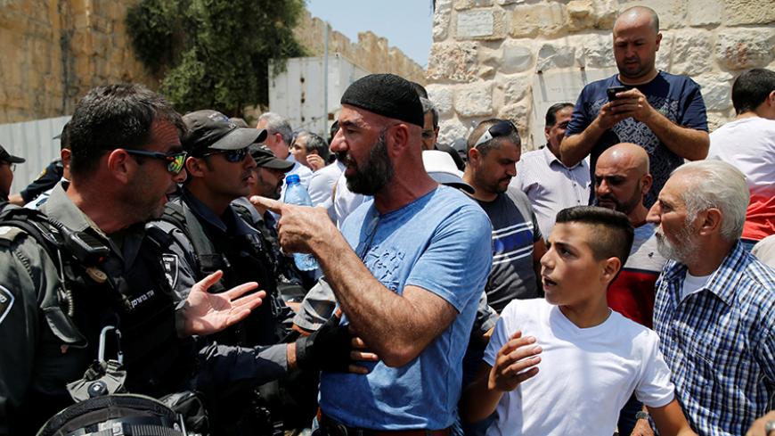A Palestinian argues with an Israeli border police officer during scuffles that erupted after Palestinians held prayers just outside Jerusalem's Old City in protest over the installation of metal detectors placed at an entrance to the Old City's compound known to Muslims as Noble Sanctuary and to Jews as Temple Mount July 17, 2017. REUTERS/Ammar Awad - RTX3BRG8