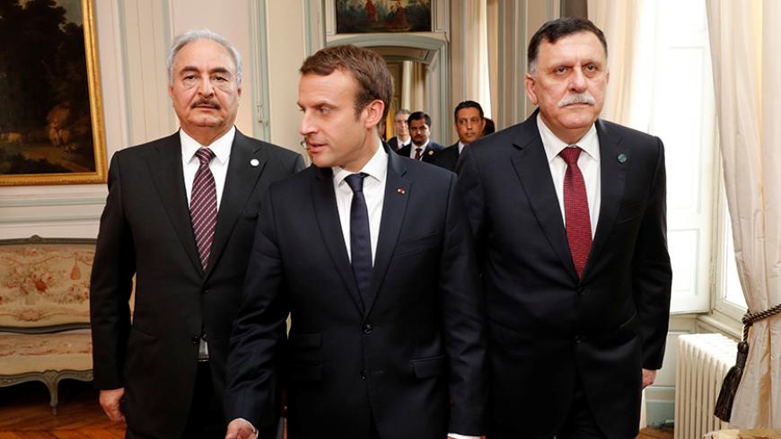 French President Emmanuel Macron walks with Libyan Prime Minister Fayez al-Sarraj (R) and General Khalifa Haftar (L), commander in the Libyan National Army (LNA), before a meeting for talks over a political deal to help end Libyaís crisis in La Celle-Saint-Cloud near Paris, France, July 25, 2017.  REUTERS/Philippe Wojazer/POOL - RTX3CUEL