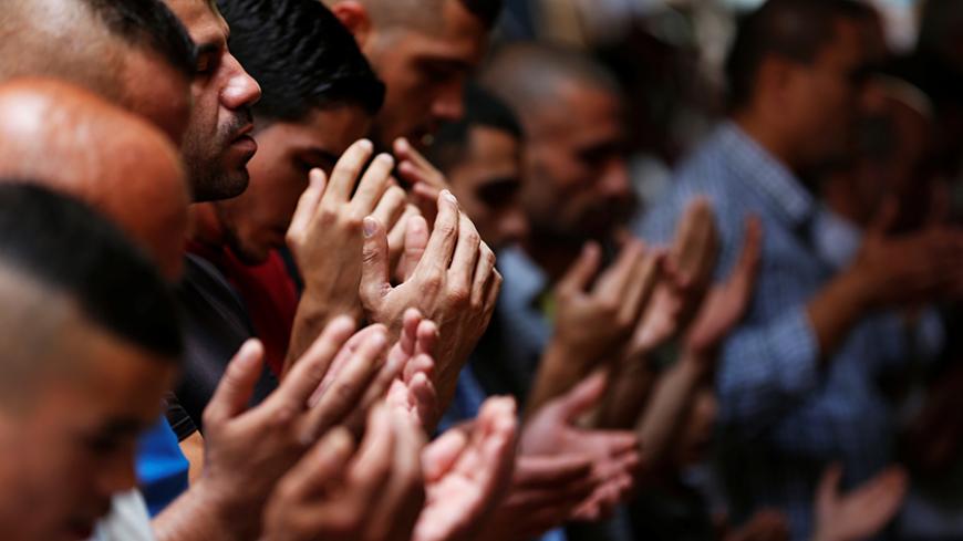 Palestinian men pray outside the compound known to Muslims as Noble Sanctuary and to Jews as Temple Mount, in Jerusalem's Old City July 26, 2017. REUTERS/Ronen Zvulun - RTX3CYQ1