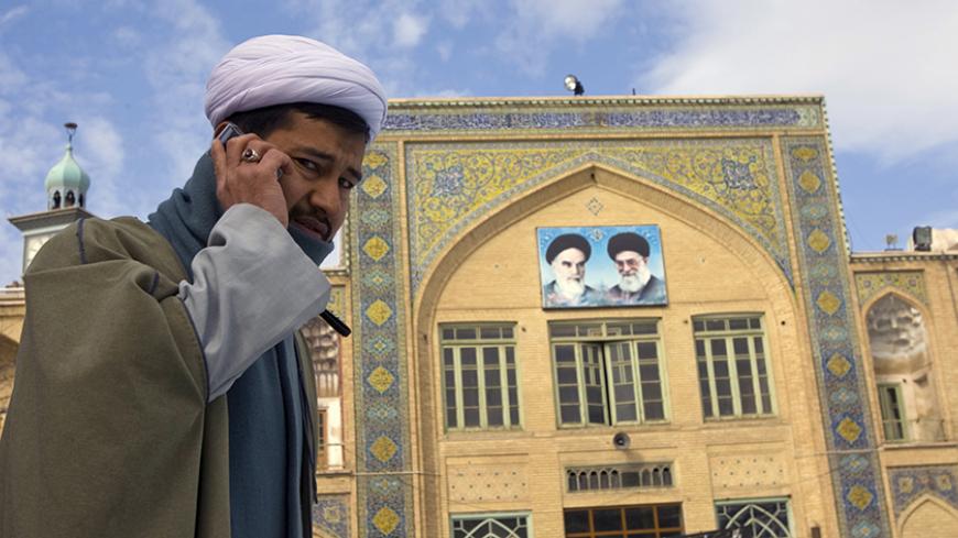 A cleric speaks on his mobile phone on the campus of the Seminary in Qom, 120 km (75 miles) south of Tehran February 3, 2009. REUTERS/Caren Firouz  (IRAN) - RTXB72O