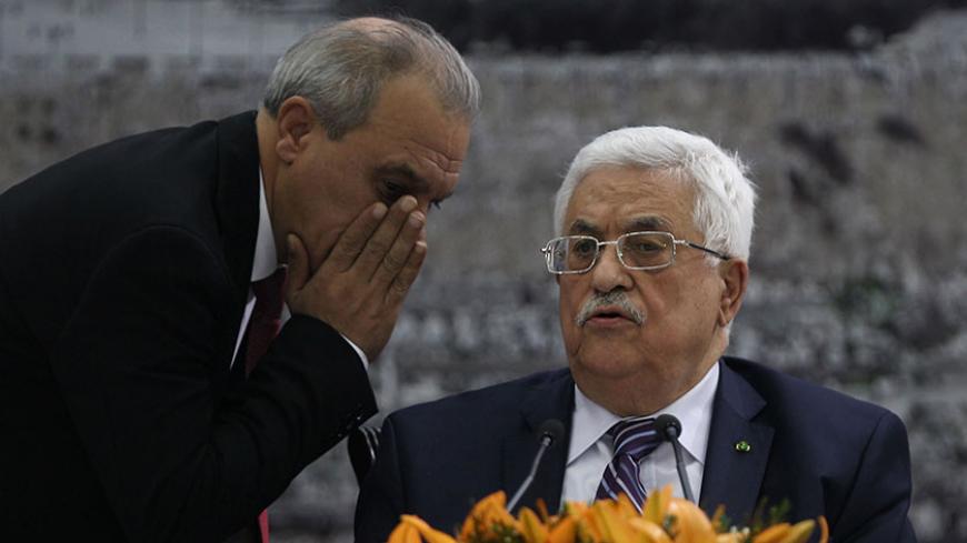 Director of Palestinian General Intelligence in the West Bank Majid Faraj (L) whispers to President Palestinian president Mahmud Abbas during a meeting where he requested to join 15 United Nations agencies, abandoning pledges to refrain from doing so during nine months of talks that were to end April 29, at his headquarters in the West Bank city of Ramallah on April 1, 2014. AFP PHOTO / ABBAS MOMANI        (Photo credit should read ABBAS MOMANI/AFP/Getty Images)
