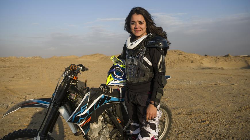 Egyptian female biker Yara Shalaby poses next to her trailbike during a ride in the desert on the outskirts of the capital Cairo on December 30, 2015. Shalaby, an engineer who has been driving motorbikes for two years, says desert riding requires good physical condition to overcome obstacles and sand dunes. AFP PHOTO / KHALED DESOUKI / AFP / KHALED DESOUKI        (Photo credit should read KHALED DESOUKI/AFP/Getty Images)