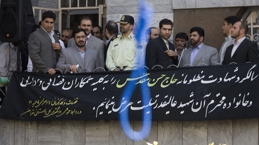 Tehran Prosecutor General Saeed Mortazavi (2nd L) attends the execution by hanging of Majid Kavousifar and Hossein Kavousifar in Tehran August 2, 2007. Iran hanged Majid and Hossein, the killers of a judge, Hassan Moghaddas, who had jailed several reformist dissidents, before a crowd of hundreds of people on Thursday. The banner reads: "We give our condolences to all our judiciary colleagues and the deceased family on the anniversary of the martyrdom of Hassan Moghaddas". REUTERS/Morteza Nikoubazl (IRAN) - 