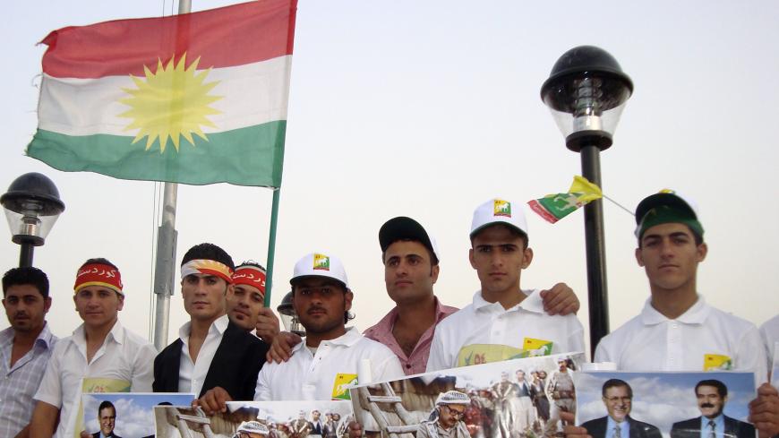 Supporters of the Patriotic Union of Kurdistan (PUK) hold and wave political posters and flags in Sulaimaniya, 260 km (160 miles) northeast of Baghdad July 9, 2009.  Iraqi Kurds going to the polls this month are losing interest in age-old battles with Baghdad over land or oil, and starting to care more about corruption plaguing their largely autonomous northern region. Picture taken July 9, 2009.  REUTERS/Tim Cokcs (IRAQ POLITICS ELECTIONS CONFLICT) - GM1E57E1QWK01
