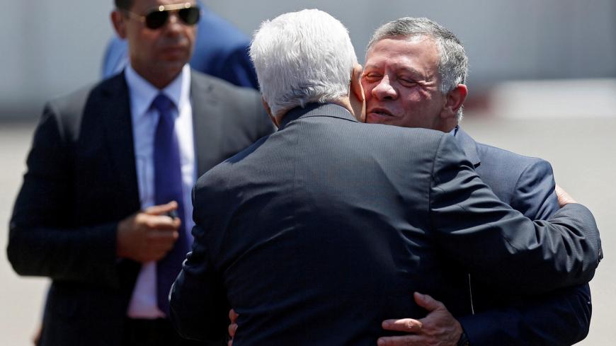Jordan's King Abdullah II is hugged by Palestinian President Mahmoud Abbas upon the king's arrival in the West Bank city of Ramallah, August 7, 2017. REUTERS/Mohamad Torokman - RTS1APAM