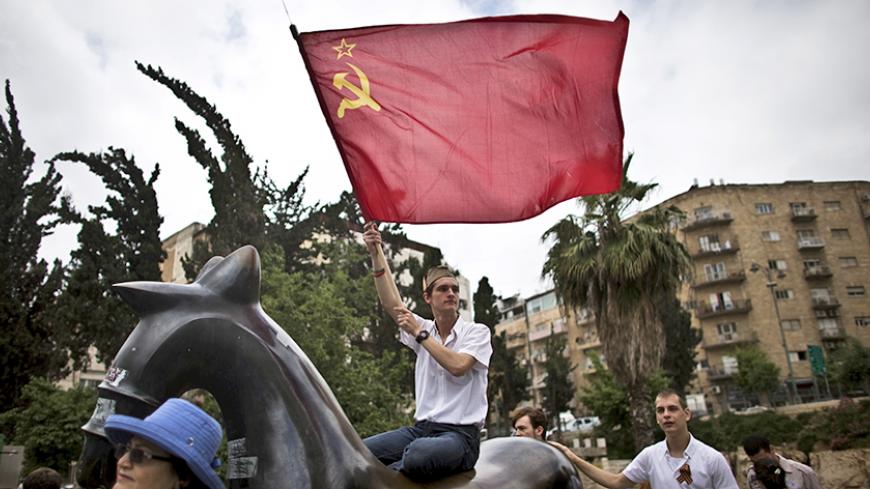 An Israeli waves a Soviet flag during a march in Jerusalem commemorating the 70th anniversary of VE (Victory in Europe) Day May 10, 2015. REUTERS/Ronen Zvulun  - RTX1CBAH