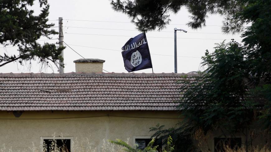 An Islamic State flag flies over the custom office of Syria's Jarablus border gate as it is pictured from the Turkish town of Karkamis, in Gaziantep province, Turkey August 1, 2015. Karkamis is a Turkish town of 10,500 people that sits directly opposite the border post. Shut for more than a year, the military sealed the crossing with a breeze block wall a few months ago. Behind it, just inside Syria, the black flag of Islamic State flaps in the breeze. Karkamis lies on the northeastern edge of a rectangle o