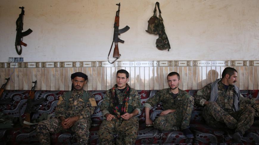 Members of the Sinjar Resistance Units (YBS), a militia affiliated with the Kurdistan Workers' Party (PKK), sit with an Arab tribal fighter (L) in a house in the village of Umm al-Dhiban, northern Iraq, April 30, 2016. They share little more than an enemy and struggle to communicate on the battlefield, but together two relatively obscure groups have opened up a new front against Islamic State militants in a remote corner of Iraq. The unlikely alliance between the Sinjar Resistance Units, an offshoot of a le