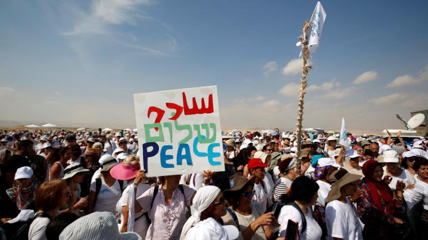 Demonstrators including Israeli and Palestinian activists take part in a demonstration in support of peace near the West Bank city of Jericho October 19, 2016. REUTERS/Mohamad Torokman   - RTX2PI50