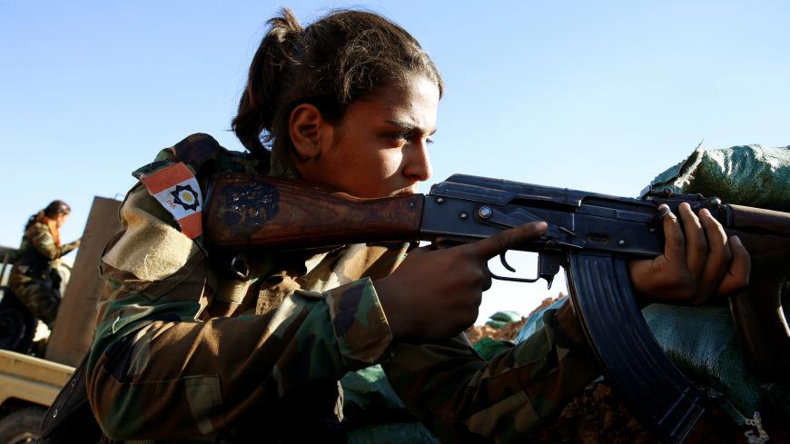 An Iranian-Kurdish female fighter fires her rifle during a fight with Islamic State militants in Bashiqa, near Mosul, Iraq November 3, 2016. REUTERS/Ahmed Jadallah - RTX2RRIZ