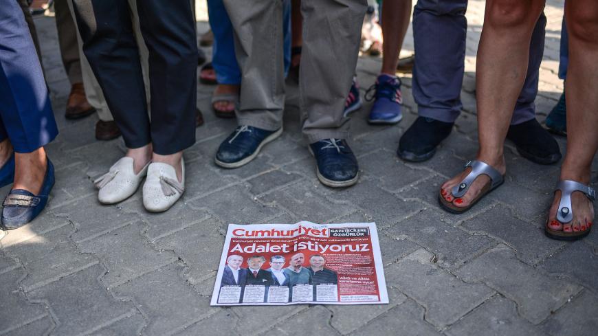 Demonstrators stand around a copy of the daily Cumhuriyet newspaper during a rally in the Silivri district of  Istanbul on September 11, 2017. 
The controversial trial of staff from Turkey's main opposition daily resumes on September 11, 2017 in a case seen as a test for press freedom under President Recep Tayyip Erdogan.  / AFP PHOTO / OZAN KOSE        (Photo credit should read OZAN KOSE/AFP/Getty Images)
