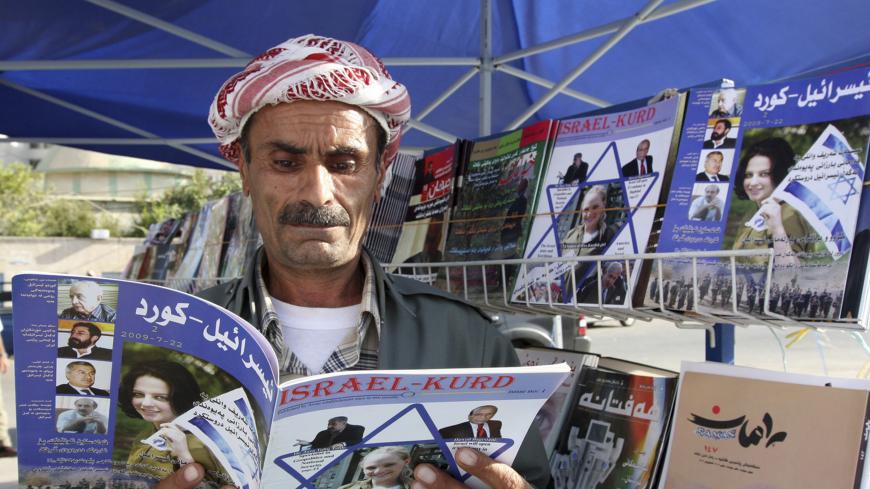 A man reads a copy of the magazine "Israel-Kurd" at a street in Arbil, 310 km (190 miles) north of Baghdad August 16, 2009. REUTERS/Azad Lashkari (IRAQ SOCIETY) - GM1E58H06K201