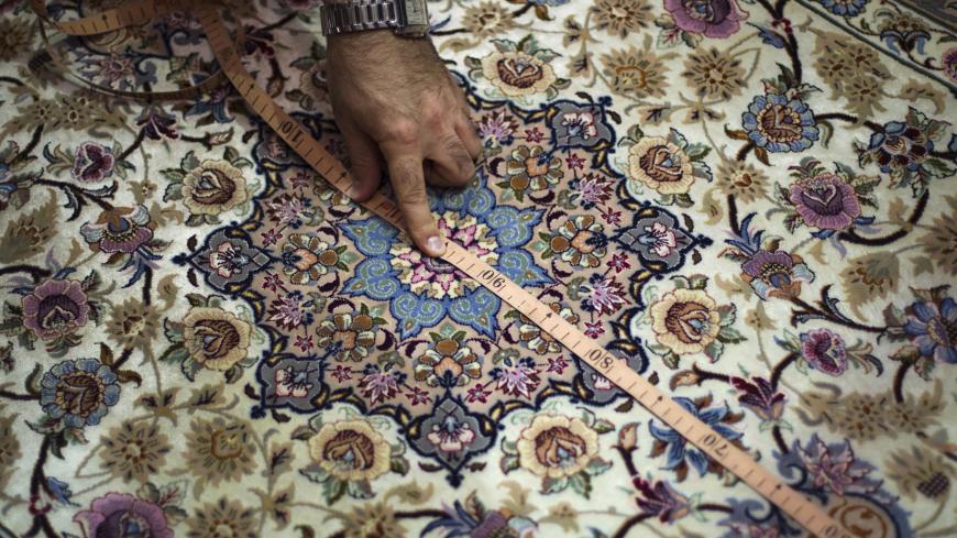 EDITORS' NOTE: Reuters and other foreign media are subject to Iranian restrictions on leaving the office to report, film or take pictures in Tehran. 
Artin Markosian, professor at Isfahan's Art University, measures a carpet during his visit to Iran's Persian handmade carpet fair in Isfahan, 450 km (280 miles) south of Tehran, November 14, 2011. Persian carpet weaving is a historical part of Iranian culture, dating back to as far as approximately 2,000 years ago. Persian carpets can be mostly divided into th
