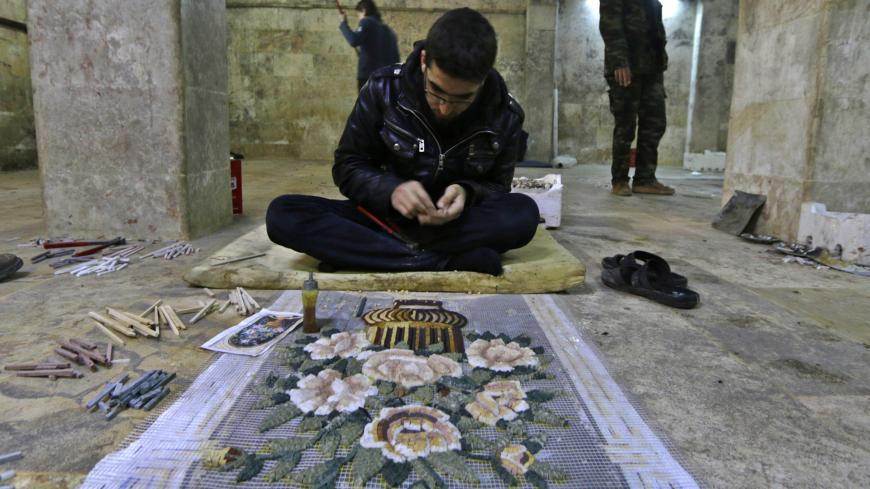 A man works on a mosaic artwork, copied from an original painting, in a workshop in Kafranbel town in the Idlib governorate January 17, 2015. The workshop has 30 workers who manufacture artistic and revolutionary mosaics in Kafranbel. Each mosaic artwork takes 5 to 10 days to complete. The artists exhibit their artwork in local and international exhibitions, and have a scheduled exhibition this month about the "Syrian Revolution" in Turkey. Picture taken January 17, 2015. REUTERS/Khalil Ashawi  (SYRIA - Tag