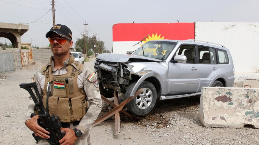 A member of the Iraqi Kurdish security forces stands guard next to the car of Mohammed Younis, a senior official of Iraq's state-run North Gas Company (NGC) who was killed by gunmen, in the northern oil city of Kirkuk, Iraq, May 2, 2017.  REUTERS/Ako Rasheed     TPX IMAGES OF THE DAY - RC1FC8168D00
