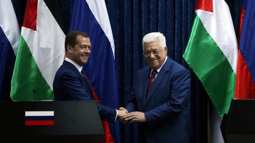 Russia's Prime Minister Dmitry Medvedev (L) shakes hands with Palestinian President Mahmoud Abbas after a joint news conference in the West Bank city of Jericho November 11, 2016. REUTERS/Mohamad Torokman   - S1AEUMFKOAAB