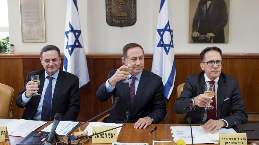 Israeli Prime Minister Benjamin Netanyahu (C), Transport Minister Yisrael Katz (L) and Cabinet Secretary Tzachi Braverman (R) raise a toast to mark the upcoming Jewish holiday of Passover at the weekly cabinet meeting in Jerusalem April 9, 2017. REUTERS/Abir Sultan/Pool - RC1188FDE160