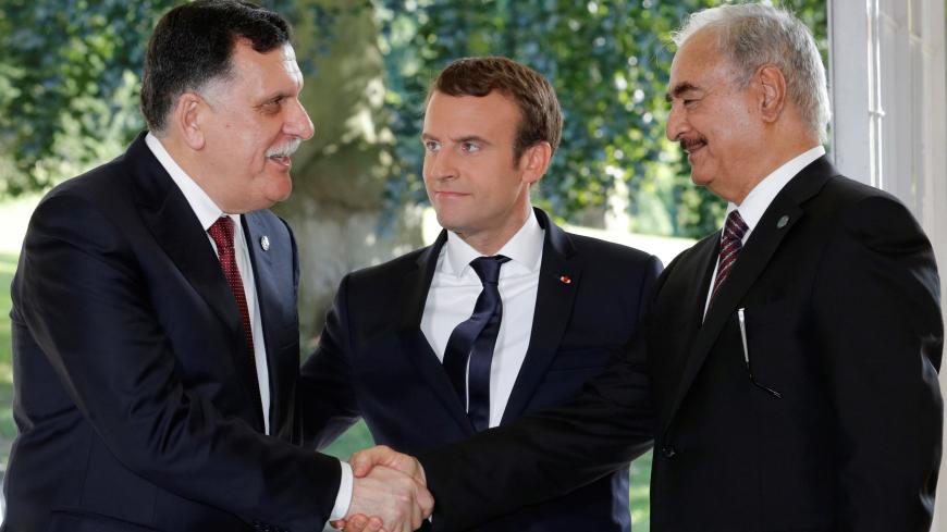 French President Emmanuel Macron stands between Libyan Prime Minister Fayez al-Sarraj (L), and General Khalifa Haftar (R), commander in the Libyan National Army (LNA), who shake hands after talks over a political deal to help end Libyaís crisis in La Celle-Saint-Cloud near Paris, France, July 25, 2017.  REUTERS/Philippe Wojazer - RC1DE481DA80