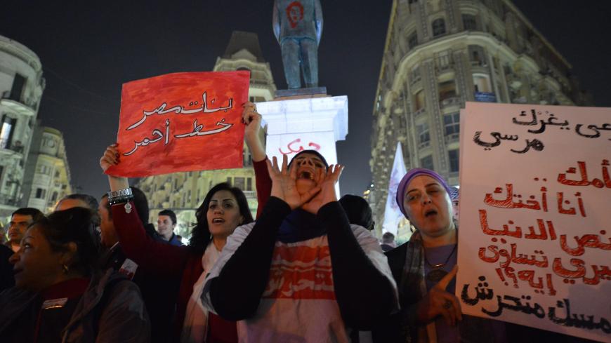Egyptian protesters hold up placards and shout slogans during a demonstration in Cairo against sexual harassment on February 12, 2013. Egyptian protesters took to the street again to demand an end to sexual violence, as campaigns against the repeated attacks in central Cairo pick up steam. Sexual harassment has long been a problem in Egypt, but recently the violent nature and frequency of the attacks have raised the alarm.   AFP PHOTO / KHALED DESOUKI        (Photo credit should read KHALED DESOUKI/AFP/Gett