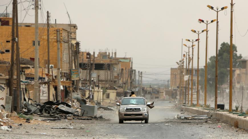 A car drives through a damaged street on the outskirts of Deir Ezzor on September 24, 2017, as Syrian government forces continue to press forward with Russian air cover in the offensive against Islamic State group jihadists across the province. / AFP PHOTO / STRINGER        (Photo credit should read STRINGER/AFP/Getty Images)