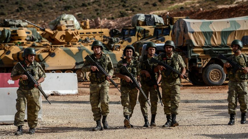 Turkish soldiers stand near armoured vehicles during a demonstration in support of the Turkish army's Idlib operation near the Turkey-Syria border near Reyhanli, Hatay, on October 10, 2017.
The Turkish army has launched a reconnaissance mission in Syria's largely jihadist-controlled northwestern Idlib province in a bid to create a de-escalation zone, the military said on October 9.  / AFP PHOTO / ILYAS AKENGIN        (Photo credit should read ILYAS AKENGIN/AFP/Getty Images)